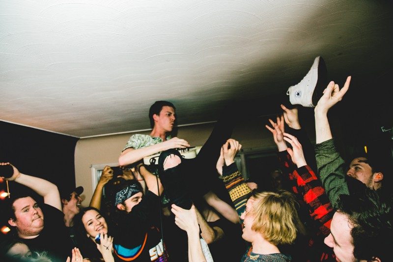 Lukas Foote of Fighting Season keeps pace while suspended in a crowd surf.