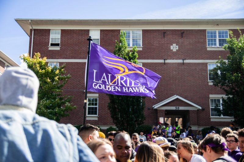 Photo fo a Laurier flag with a crowd visible in the foregrond.