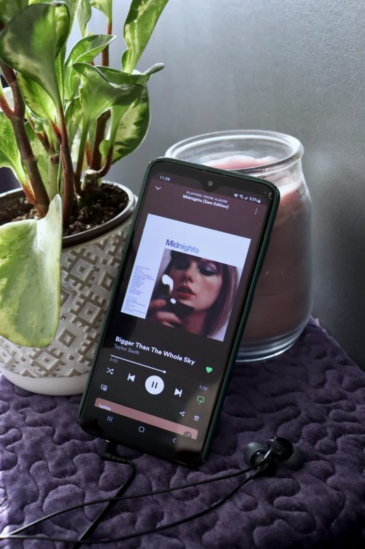 Phone with Spotify open, playing tracks from Taylor Swift's album "Midnight"