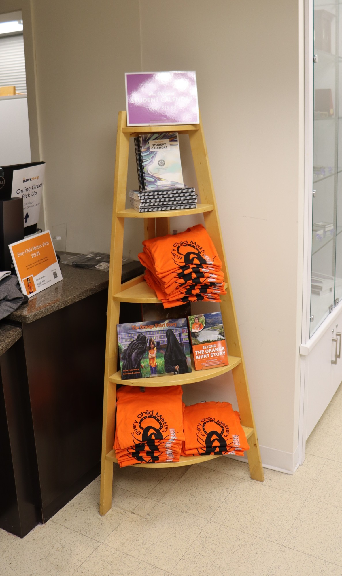 A bookshelf with orange shirt