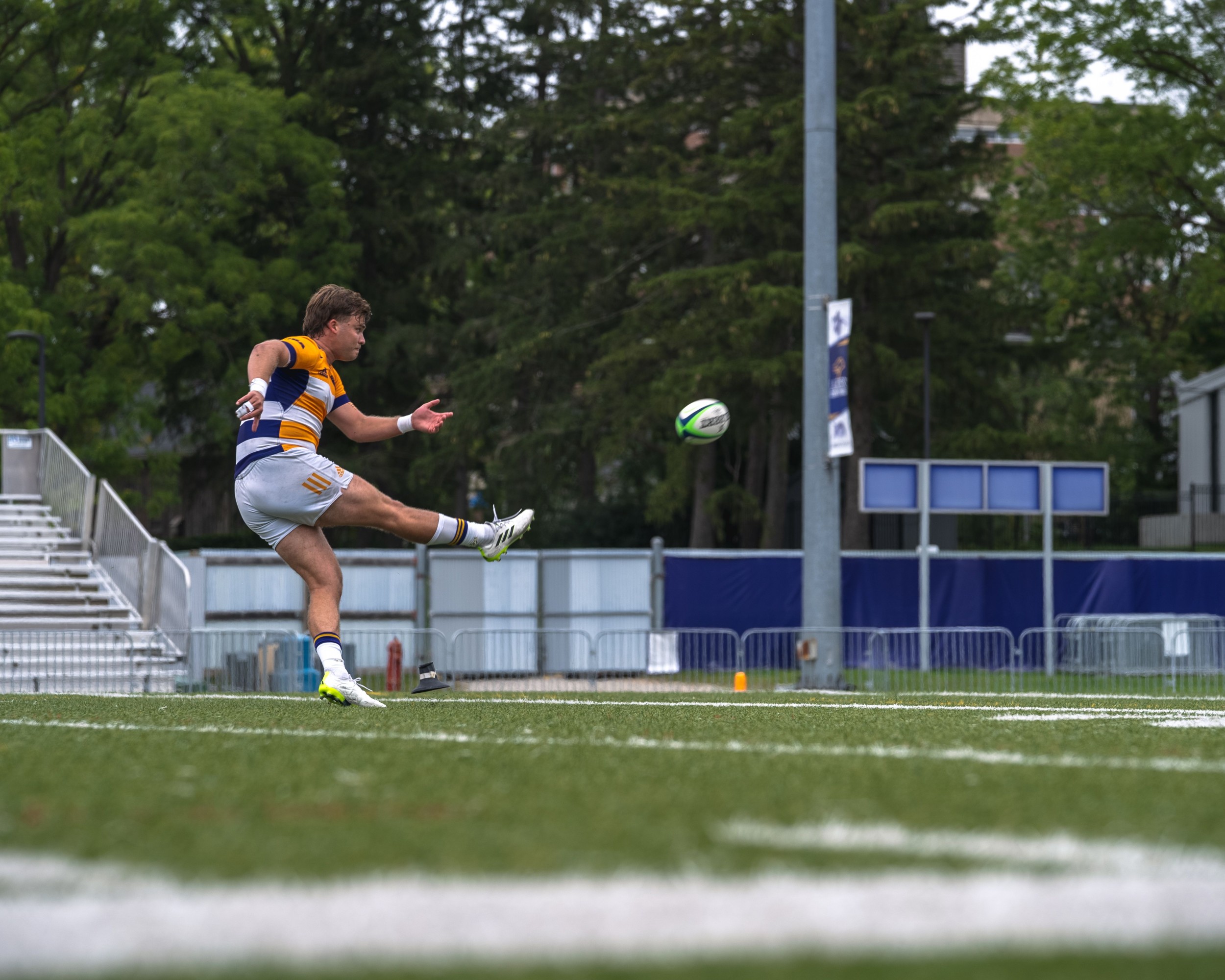 Laurier Men's rugby player kicking the ball in a conversion