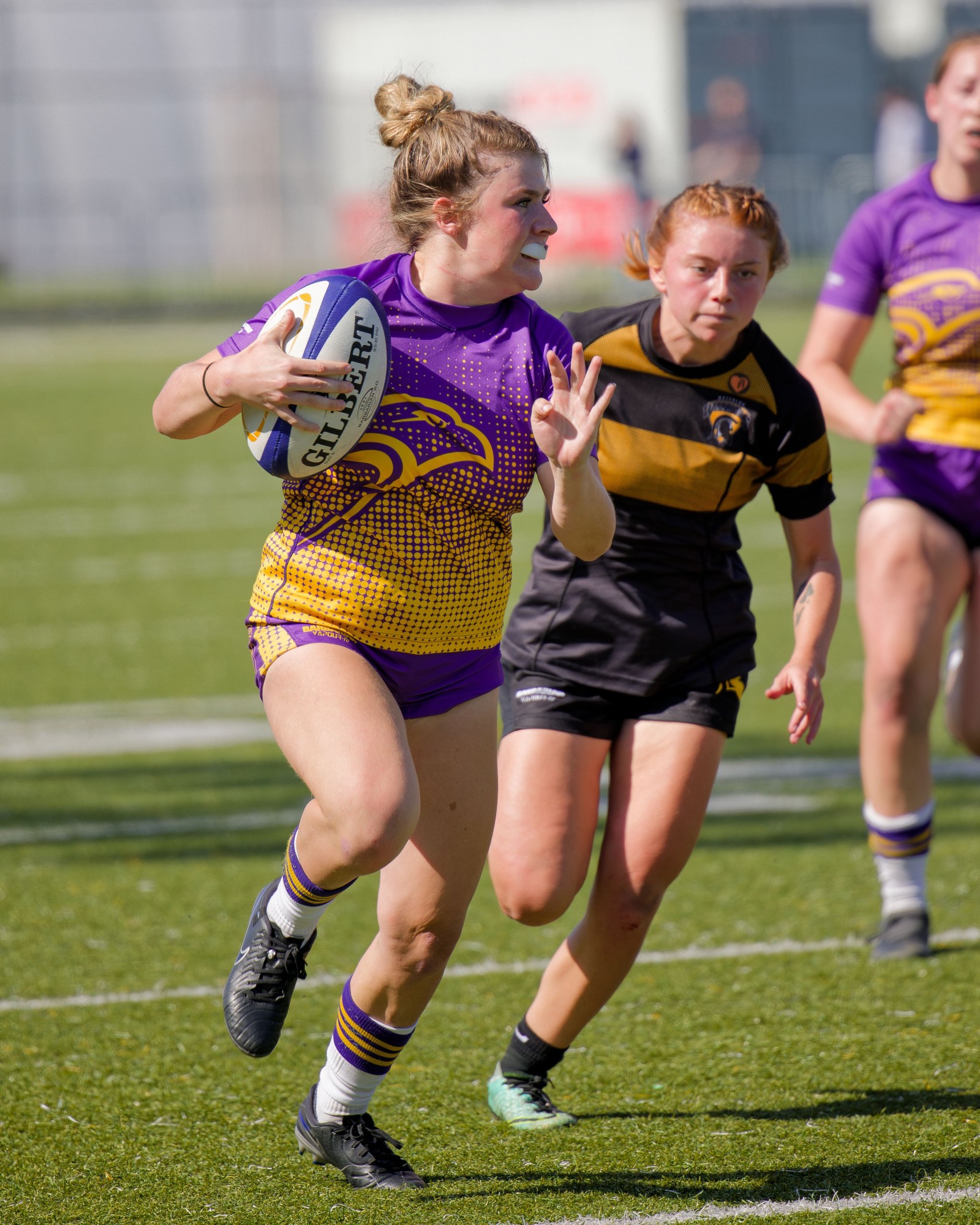Laurier women's rugby player running with the ball